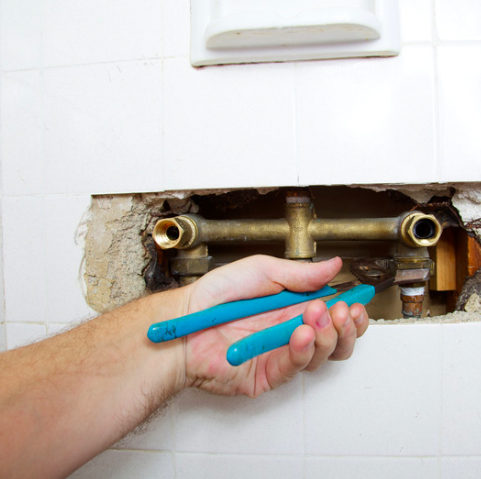 A plumber working on a copper pipe